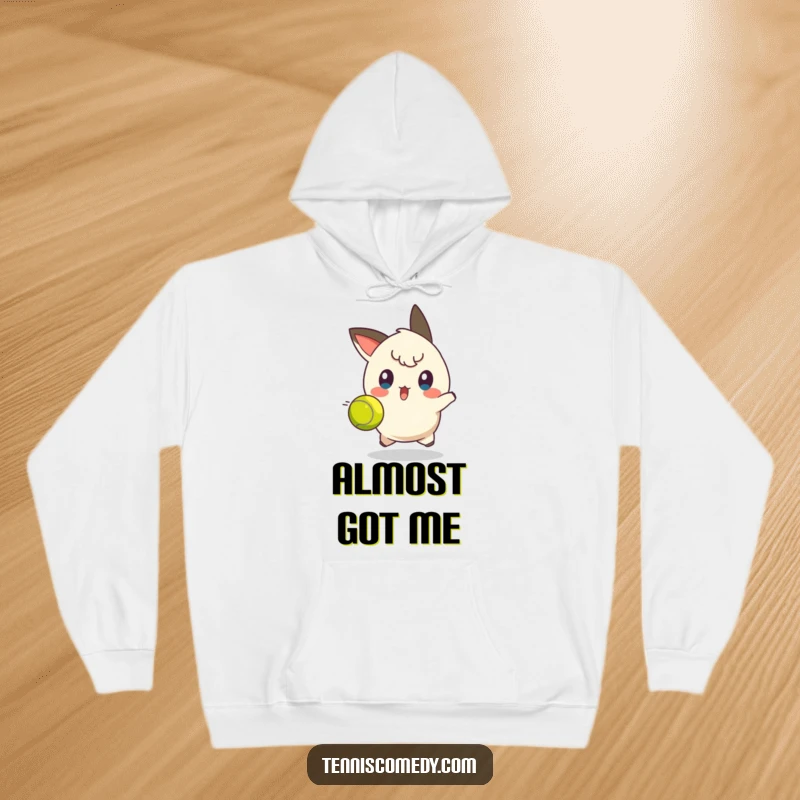 Funny tennis dodge hoodie depicting a character with a shocked expression, caught off guard by a fast tennis ball.